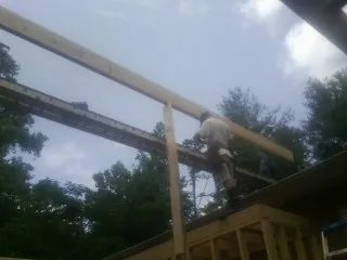 Carpenter setting a ridge beam over a new addition frame — Ice Dam Removal by Roofing Brothers in Bonney Lake