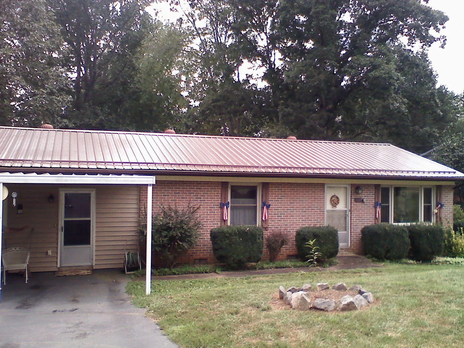 Bronze metal roof and carport on a brick ranch home — Roof Repair work by our crew in Bonney Lake